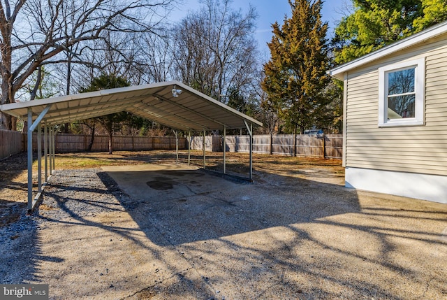 view of parking featuring a carport, driveway, and fence