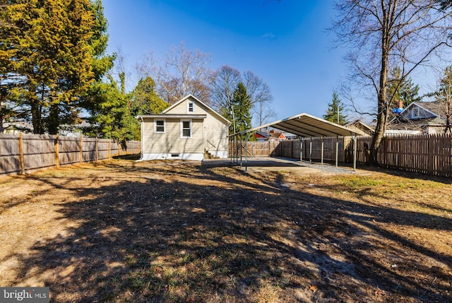 back of house featuring a detached carport and a fenced backyard