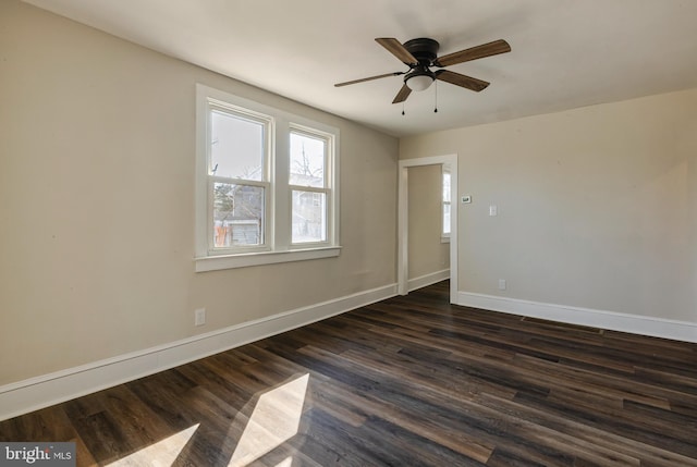 spare room with a ceiling fan, baseboards, and dark wood-style flooring