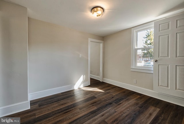 interior space featuring baseboards and dark wood-style flooring