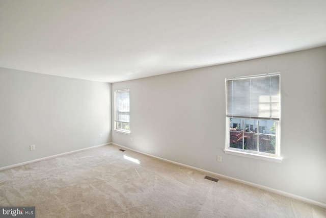 carpeted empty room with visible vents and baseboards