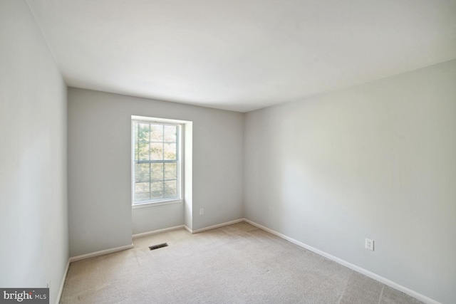 unfurnished room featuring baseboards, visible vents, and carpet floors