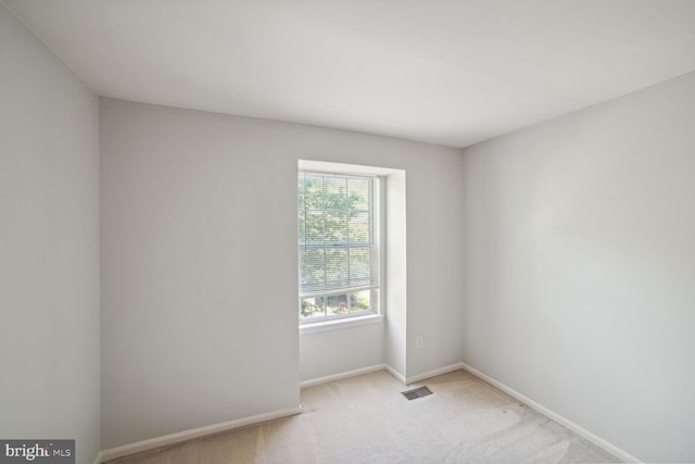 unfurnished room with visible vents, baseboards, and carpet flooring