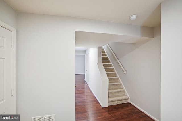 stairs featuring visible vents, baseboards, and wood finished floors