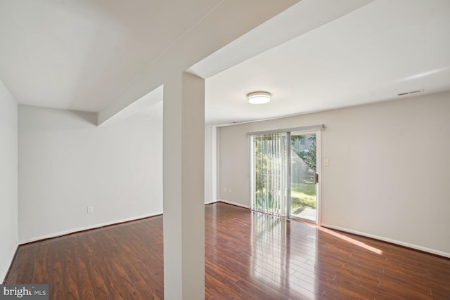 empty room with visible vents, baseboards, and wood finished floors