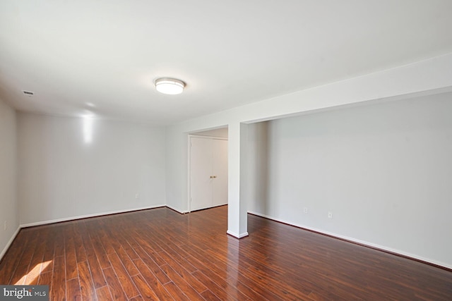 below grade area with visible vents, baseboards, and wood finished floors