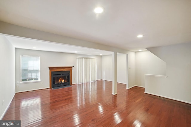 unfurnished living room featuring a fireplace with flush hearth, recessed lighting, and hardwood / wood-style floors