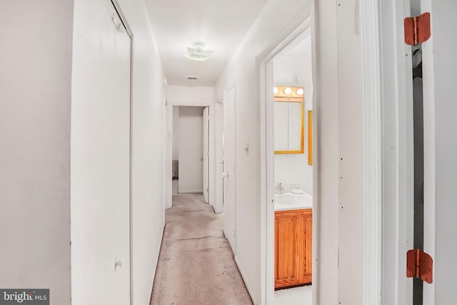 hall with a sink and concrete flooring