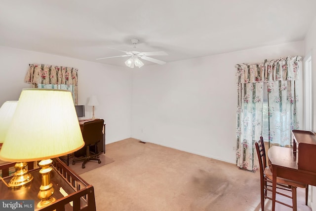 office space featuring light carpet and ceiling fan