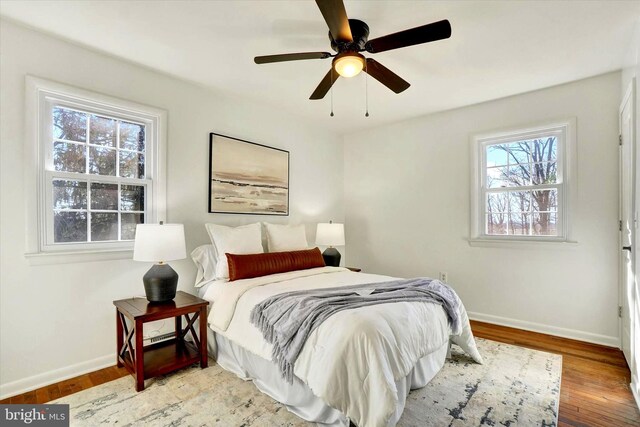 bedroom featuring a ceiling fan, baseboards, and wood finished floors