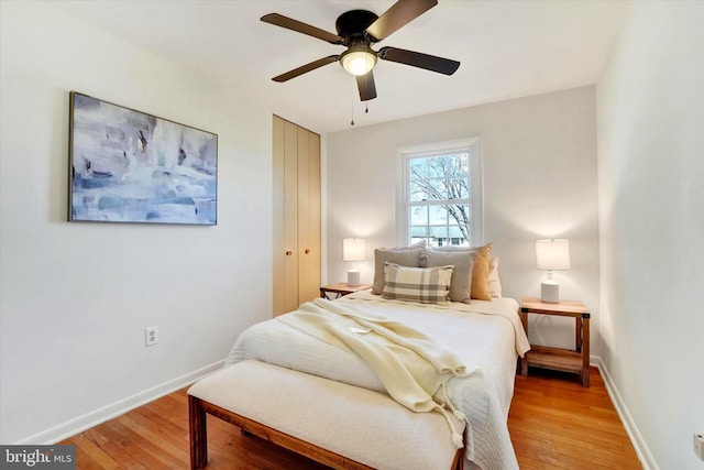 bedroom featuring light wood-style floors, baseboards, and a closet