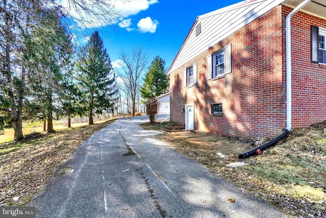 view of home's exterior with brick siding and a garage