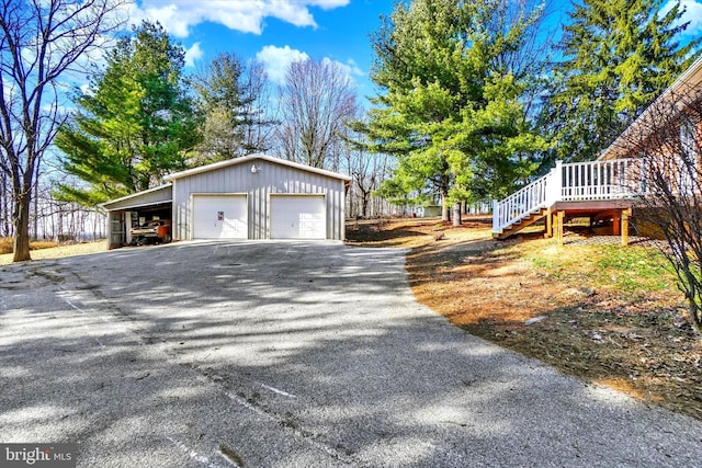 view of home's exterior featuring stairs, a detached garage, and an outdoor structure