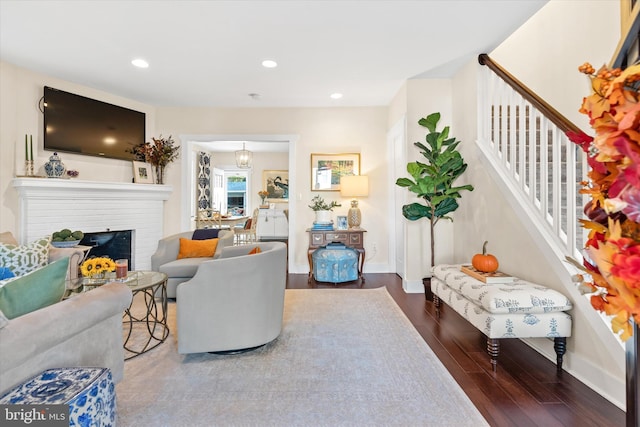 living room featuring stairway, recessed lighting, baseboards, and wood finished floors