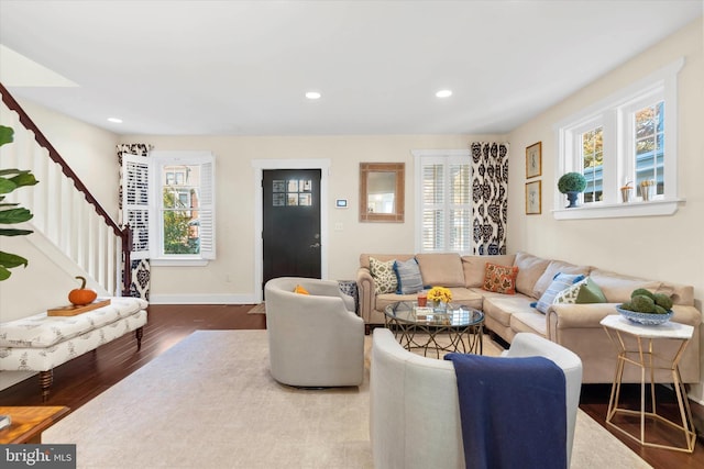 living room with recessed lighting, stairway, a healthy amount of sunlight, and wood finished floors