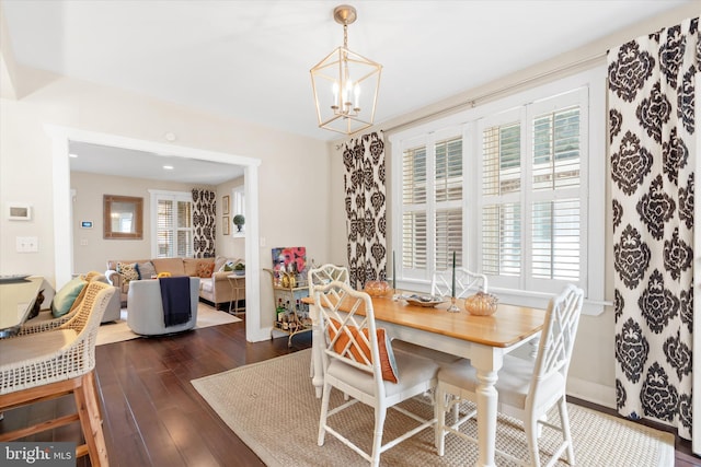 dining room with dark wood-style floors, baseboards, and a chandelier