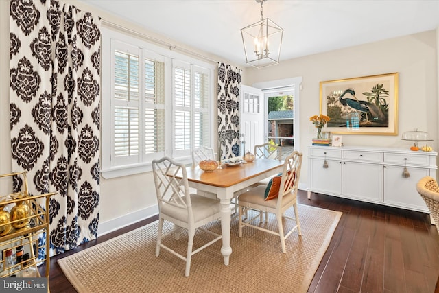 dining area featuring dark wood finished floors, a chandelier, and baseboards