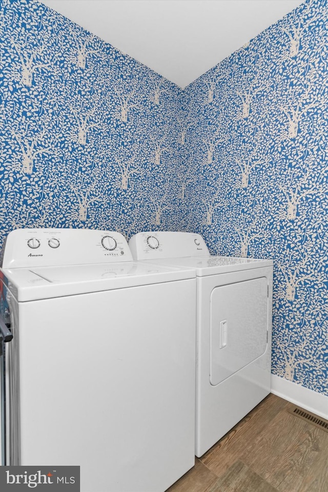 washroom with wood finished floors, visible vents, baseboards, laundry area, and independent washer and dryer