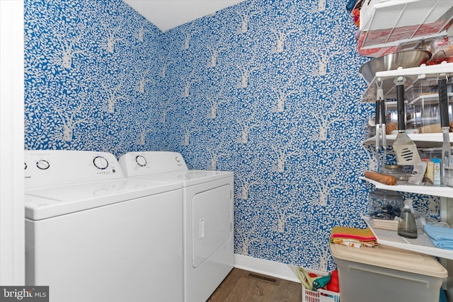 washroom featuring laundry area, washer and dryer, visible vents, and wood finished floors