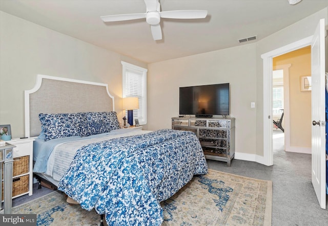 carpeted bedroom featuring baseboards, visible vents, and ceiling fan