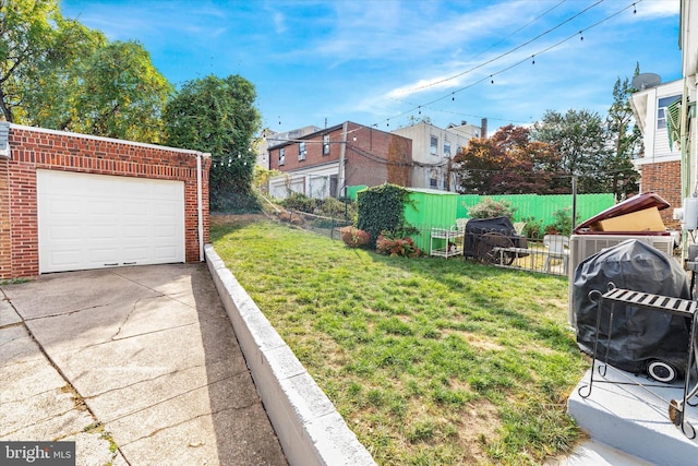 view of yard featuring concrete driveway and fence