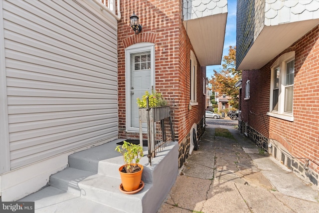 doorway to property featuring brick siding