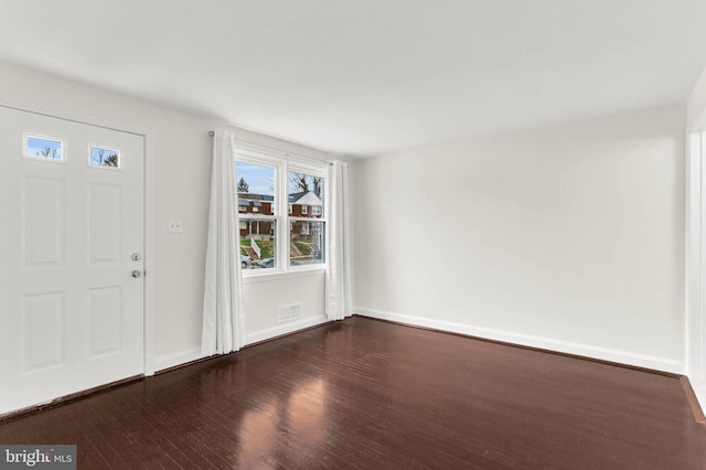 foyer entrance featuring dark wood finished floors, baseboards, and visible vents