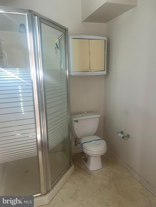 full bathroom with baseboards, toilet, and a shower stall