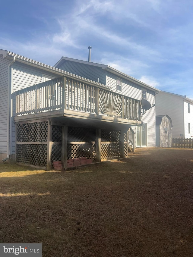 back of property featuring stairs, a lawn, and a wooden deck