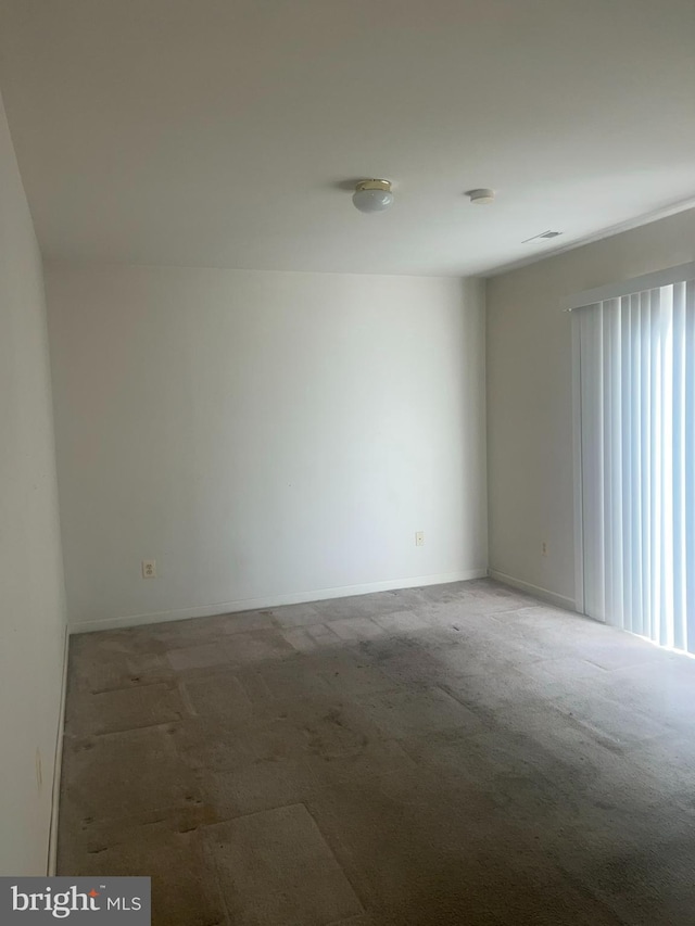 unfurnished room featuring visible vents, baseboards, and carpet