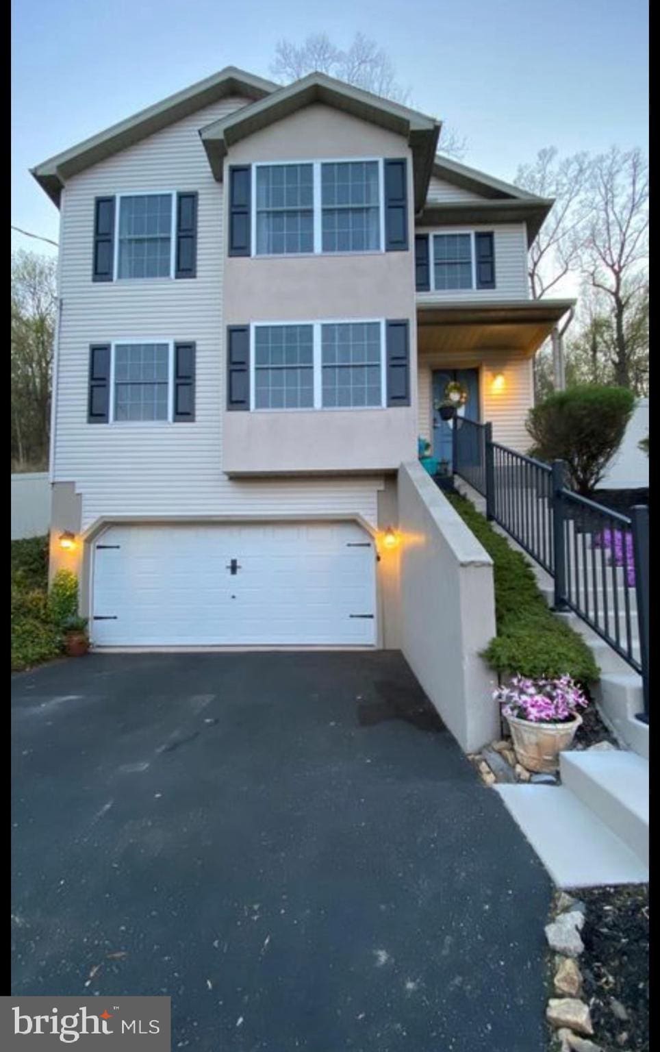 view of front facade with aphalt driveway and an attached garage