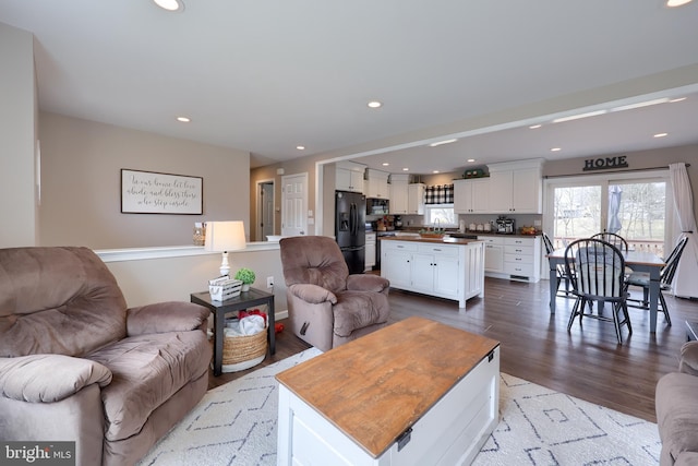 living room with recessed lighting and dark wood-type flooring