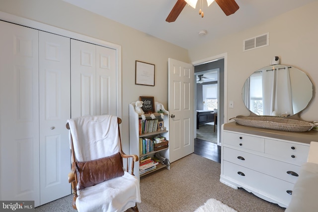 living area featuring light colored carpet, visible vents, and ceiling fan