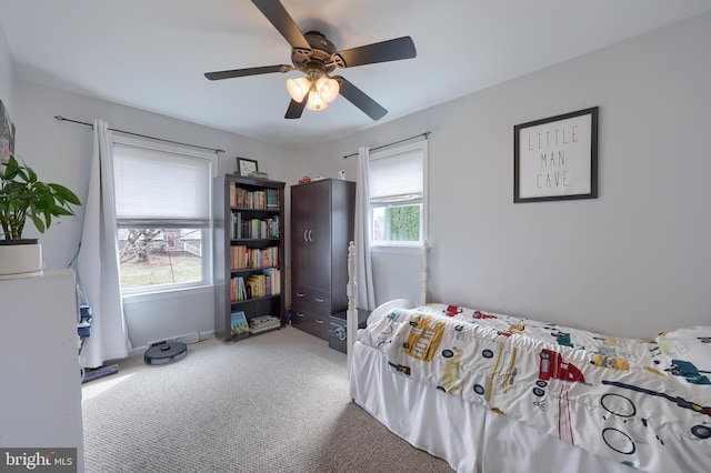 carpeted bedroom with multiple windows and a ceiling fan