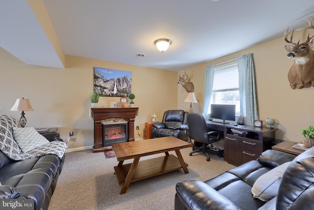 carpeted home office with a glass covered fireplace and baseboards