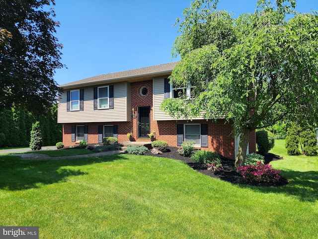 split foyer home with brick siding and a front lawn