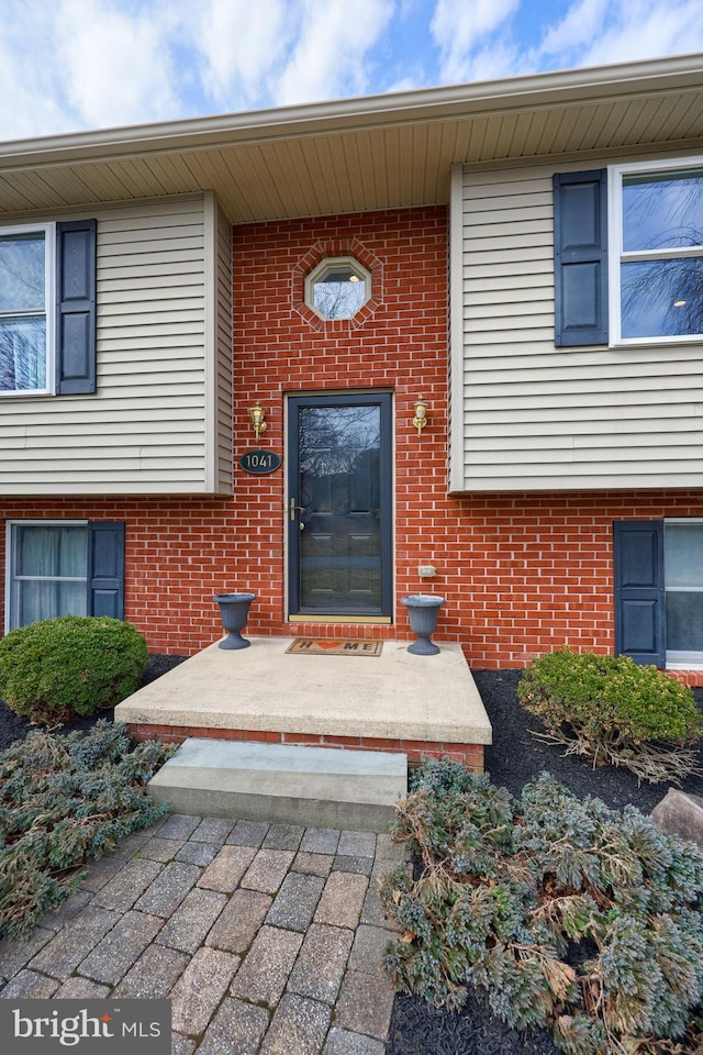 doorway to property with brick siding