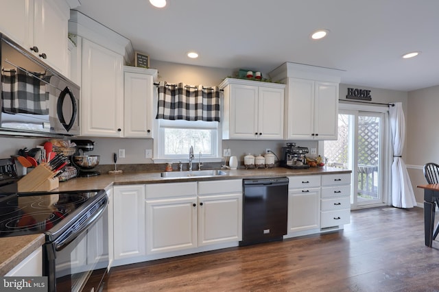 kitchen featuring dark wood-style flooring, white cabinetry, black appliances, and a sink