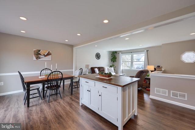 kitchen featuring dark wood-style floors, visible vents, white cabinets, and butcher block counters