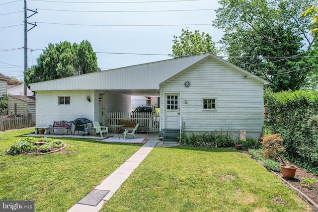 rear view of house with a wooden deck, a yard, and fence