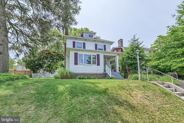 traditional style home with a front lawn and fence