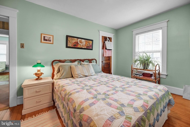 bedroom with baseboards and wood finished floors