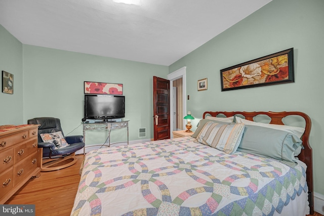 bedroom with visible vents and wood finished floors