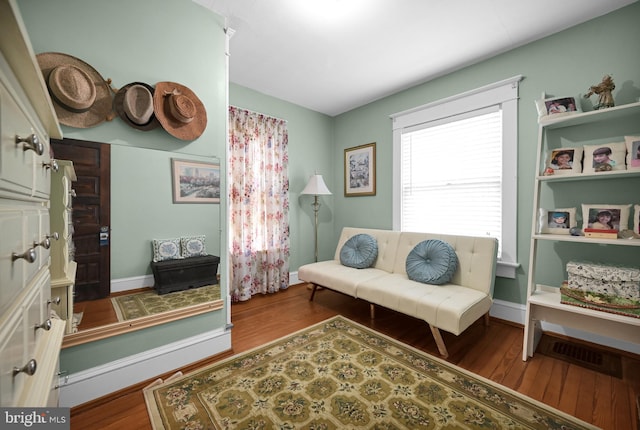 sitting room with visible vents, baseboards, and wood finished floors