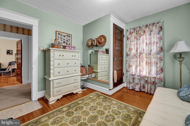 bedroom with wood finished floors and baseboards