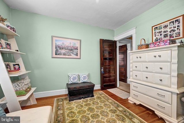 living area with baseboards and wood finished floors