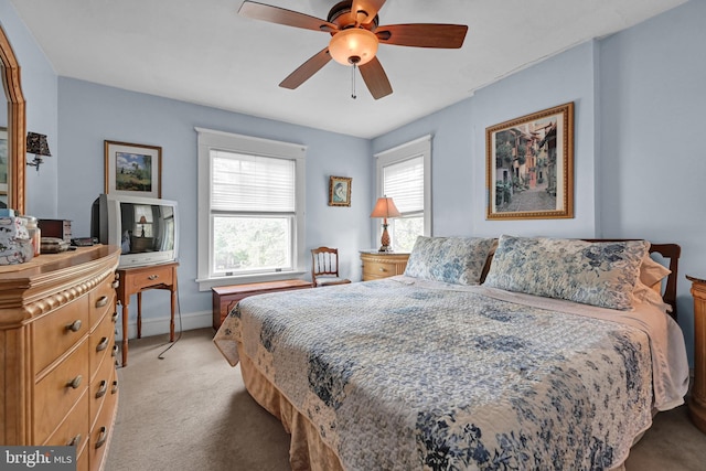 bedroom with light colored carpet, baseboards, and ceiling fan