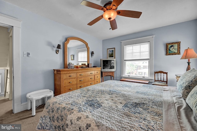 bedroom with a ceiling fan, baseboards, and carpet floors