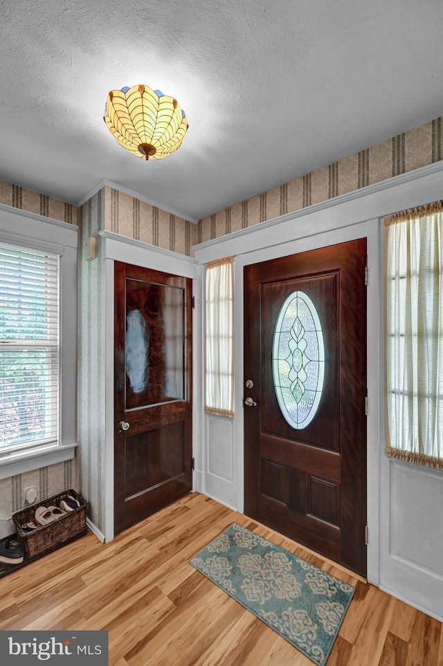 entryway with light wood-style flooring and a textured ceiling