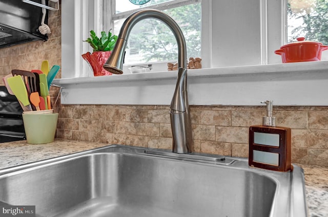 room details featuring decorative backsplash and a sink